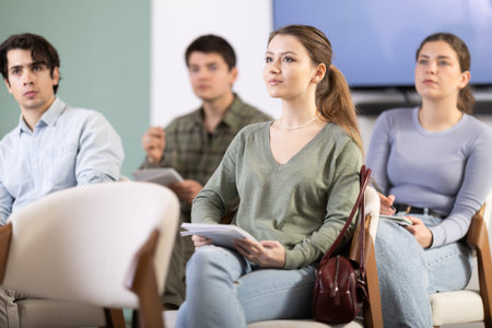 Young girl taking part in a university seminar with other students