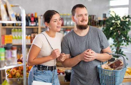 Couple man and woman choosing groceries in store