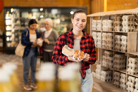 Girl selects and buys chicken eggs at grocery supermarket.