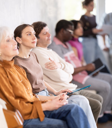 Man and a woman chat while waiting for their turn at job interview in an officeの写真素材