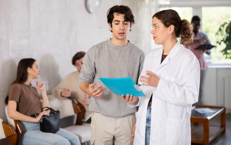 Female doctor prescribing tests to young male patient to check state of health
