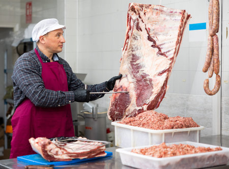 Adult male butcher holding beef ribs