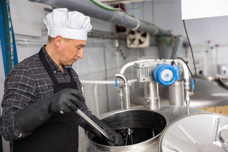 Brewmaster mixing beer components in tank