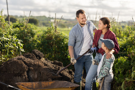 Family of farmers working with compost
