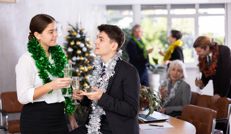 Young man flirting with girlfriend during christmas celebration in office