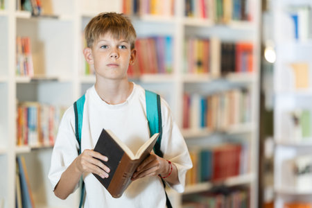 In bookstore teen boy choose book