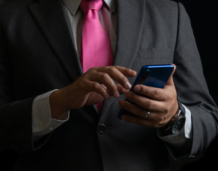 Successful businessman on black background, smoking and tie