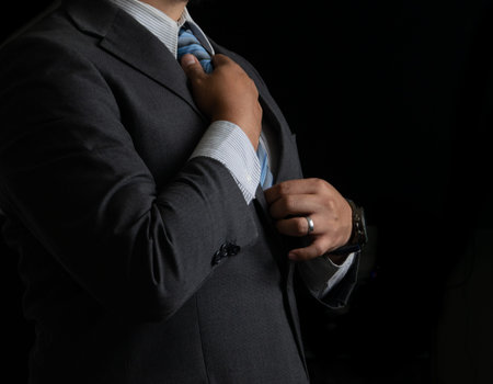 Successful businessman on black background, smoking and tie