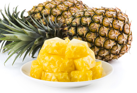 Slice of pineapple on white dishの写真素材