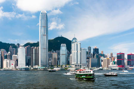 Star Ferry sailing at sea, hong kong's skyscrapers in the background.のeditorial素材