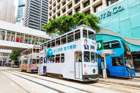 Famous double-decker trams with the background of the Modern building in Hong Kong Island.のeditorial素材