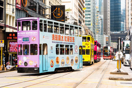 View of famous double-decker trams with the background of the Modern building in Hong Kong Island.のeditorial素材