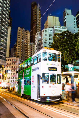 View of famous double-decker trams with the background of the Modern building in Hong Kong Island.のeditorial素材