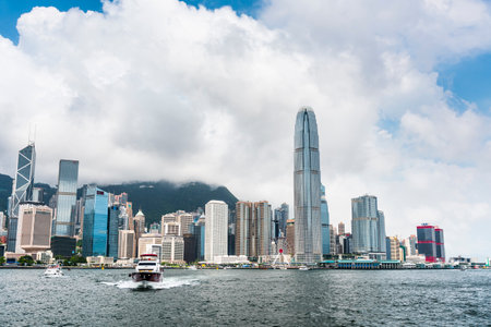 view of a yacht sailing into Hong Kong's Victoria Harbour in china. International Finance Center(IFC)のeditorial素材