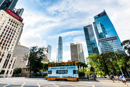 Famous double-decker trams with the background of the Modern building in Hong Kong Island.