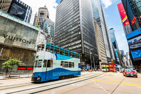 View of famous double-decker trams with the background of the Modern building in Hong Kong Island.のeditorial素材