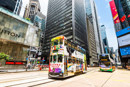 Famous double-decker trams with the skyscraper in Hong Kong.のeditorial素材