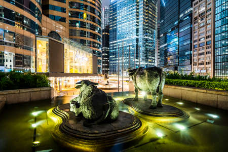 Bull sculptures and flags flying outside Exchange Square, home of the Hong Kong Stock Exchange which is currently the third-largest stock exchange in Asia. Bull sculptures outside the Hong Kong Stockのeditorial素材