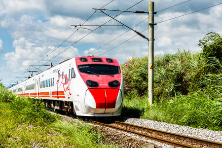 A Puyuma Express train passes through the beautiful landscape of rice paddy fields in Taitung, Taiwan.のeditorial素材