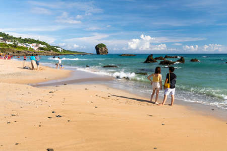 Tourists playing on the beach near Chuanfanshi Coast in Kenting National Park of Pingtung, Taiwanのeditorial素材