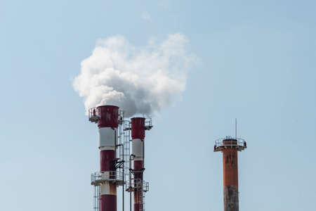 Air pollution by smoke coming out of two factory chimneys.の写真素材