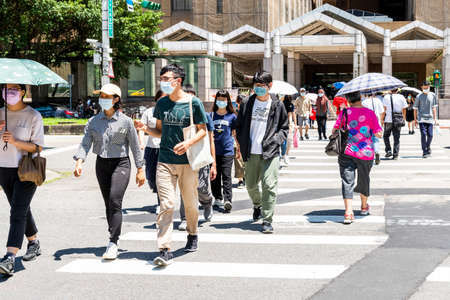 Pedestrians cross the road at the intersection in front of National Taiwan University Hospital. People wear a mask to protect themselves during the COVID-19 outbreak.のeditorial素材