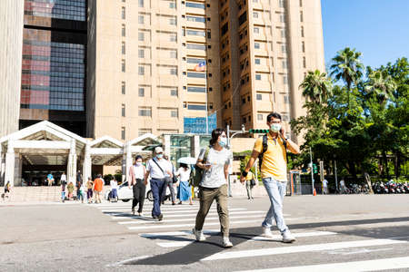 Pedestrians cross the road at the intersection in front of National Taiwan University Hospital. People wear a mask to protect themselves during the outbreak.のeditorial素材