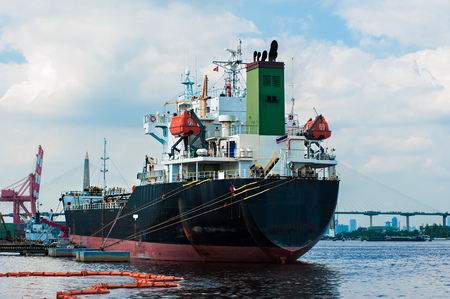 Logistic concept, Black Ship parked in the river. Waiting to dock and load the goods.の写真素材