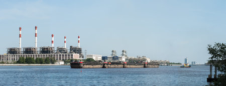 Electric power refinery plant in Thailand with boats foreground carrying ton of sand in the Chao...
