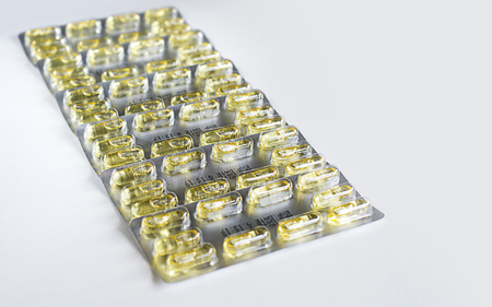 Yellow Capsule pills and package use in pharmaceutical manufacturing, drug, medicine, garlic oil, fish liver oil.の写真素材