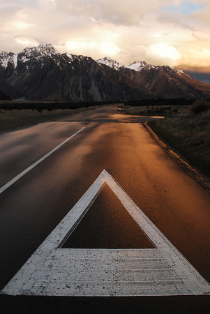 Scenic view sunset panoramic of mount with snow cap and yellow grass field along long roadの写真素材