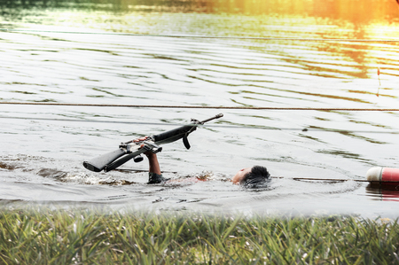 Military Soldier carry rifle in the water battle field environment trainingの写真素材