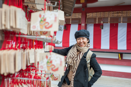 Asian senior female tourist in winter costume traveling in Japanのeditorial素材