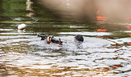Military Soldier carry rifle in the water battle field environment trainingの写真素材
