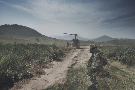 Thai Army Helicopter is landing on the open field operation site while the soldiers are preparing to jump up.の写真素材