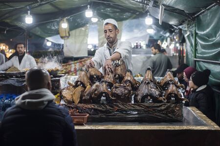 MARRAKESH, MOROCCO - April 13, 2018 - Jamaa el Fna is a public square and night market place in Marrakesh's Medina quarter (old city) Morocco. In the evening there are many food stands Roasted Sheep heads, street performance shows, attracting crowds of loのeditorial素材
