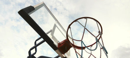 Basketball hoop with blue sky and white clouds. Close up view.の写真素材