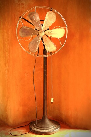Vintage old fan against orange wallの写真素材