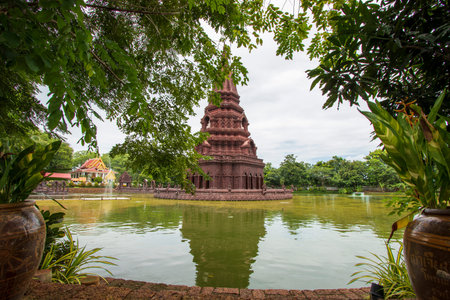 A beautiful chedi is located in the middle of the water at Huay Kaew Temple in Lop Buri Province in...