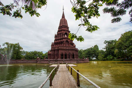A beautiful chedi is located in the middle of the water at Huay Kaew Temple in Lop Buri Province in Thailand.の写真素材