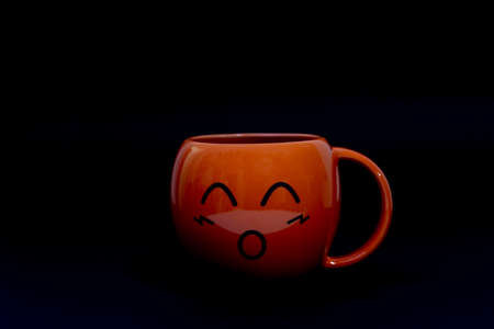 Orange ceramic coffee cups on a black backgroundの写真素材