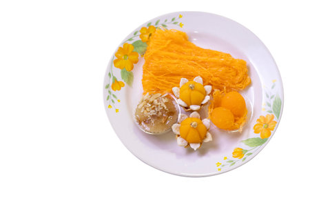 Colorful Thai desserts on a plate on a white background
