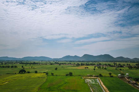 Natural high angle views and vast rice fields with the sky and mountains behind.の写真素材