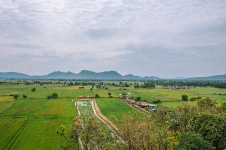Natural high angle views and vast rice fields with the sky and mountains behind.の写真素材