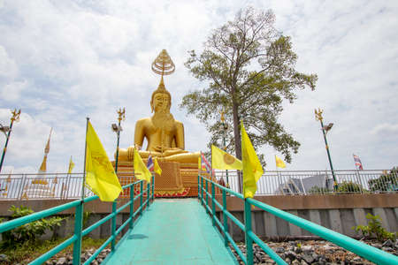A large golden Buddha image sits along the Chao Phraya River at Wat Ko Krieng in Pathum Thani Province in Thailand.の写真素材