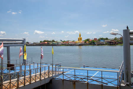 A large golden Buddha image sits along the Chao Phraya River at Wat Bang Chak in Nonthaburi Province in Thailand.のeditorial素材