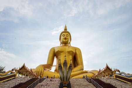 A large golden yellow Buddha image at Wat Muang, an important religious attraction in Ang Thong Province in Thailand.の写真素材