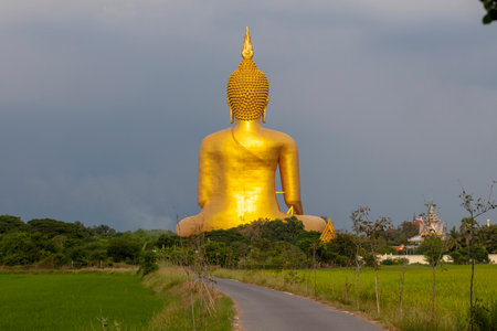 A large golden yellow Buddha image at Wat Muang, an important religious attraction in Ang Thong Province in Thailand.の写真素材