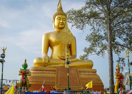 A large golden Buddha image sits along the Chao Phraya River at Wat Ko Krieng in Pathum Thani Province in Thailand.の写真素材