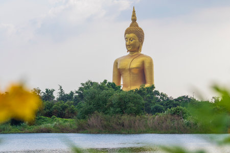 A large golden yellow Buddha image at Wat Muang, an important religious attraction in Ang Thong Province in Thailand.の写真素材